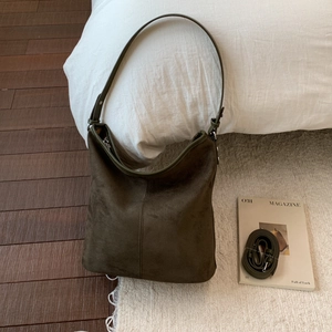 Detailed view of olive green suede tote bag with adjustable long shoulder strap