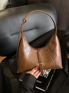 Brown vintage half-moon shoulder bag in soft leather with elegant gold metal buckle detail