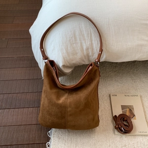 Detailed texture of brown suede hobo bag with leather strap and silver hardware