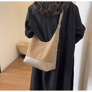 Detail of khaki suede hobo tote showing premium material texture and brand logo