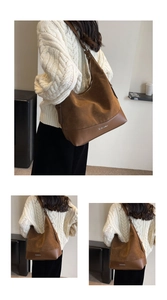 Detail of brown suede tote bag featuring leather stitching and silver metal logo