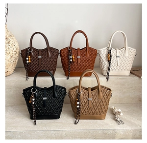 Detailed view of structured woven texture handbags in five colors on stone steps