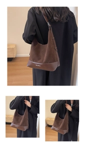 Detail view of large dark brown hobo bag with suede finish and leather base