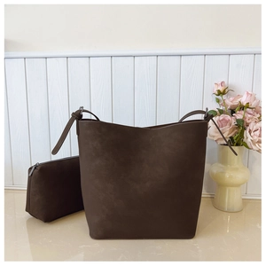 Detail of dark brown matte tote bag with matching zippered pouch on white surface