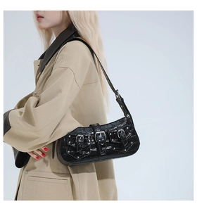 Detail of black croc-effect punk shoulder bag with silver studs and multi-buckle straps