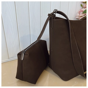 Detail of dark brown matte leather tote bag and matching pouch with silver zipper