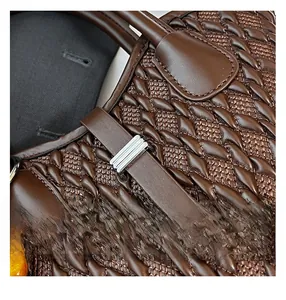 Detail view of deep brown woven handbag with silver metal buckle and premium texture
