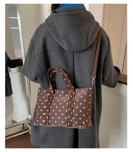 Close-up of brown polka dot tote bag showing waterproof fabric and detachable shoulder strap