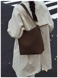 Brown vintage matte tote bag with shoulder strap styled on a beige trench coat