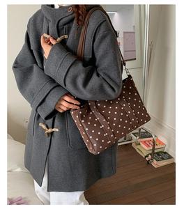 Brown polka dot tote bag styled with a grey toggle coat for casual winter fashion outfit