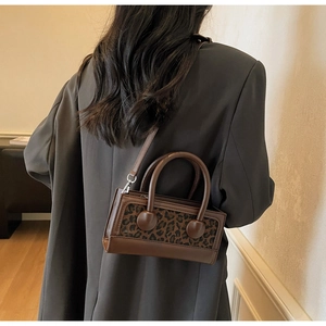 Detailed back view of a leopard print crossbody bag worn with a gray suit jacket