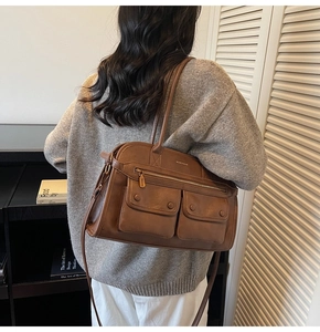 Detail of vintage brown multi-pocket crossbody bag showing leather texture and style