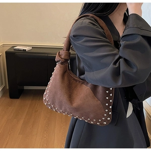 Detail of brown suede Hobo bag with silver studs and decorative knotted shoulder strap