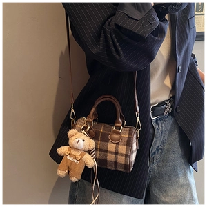 Close-up of Boston bag with British plaid pattern and cute teddy bear mascot pendant