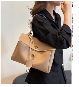 Detailed view of beige faux leather shoulder bag featuring double metal turn-lock closures