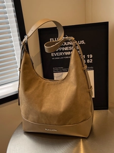 Khaki suede hobo tote bag with adjustable strap and metal logo in minimalist urban style