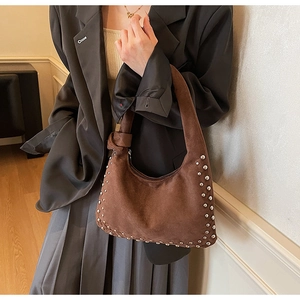 Detail of dark brown suede hobo bag with silver rivet studs and stylish knotted strap
