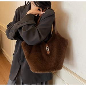 Detail of coffee brown faux fur tote bag featuring leather trim and silver metal buckle