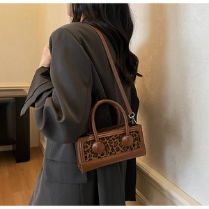Gros plan détaillé montrant le panneau léopard et la texture cuir du petit sac à main carré