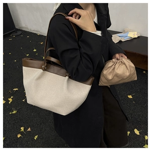 Detailed view of canvas tote bag with leather trim and matching drawstring inner pouch