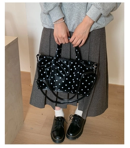 Close-up of stylish black and white polka dot tote bag with detachable shoulder strap