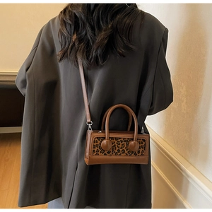 Détail du panneau léopard et des finitions en cuir marron sur un sac bandoulière