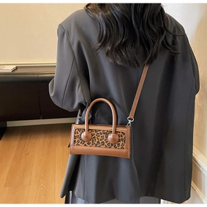 Vue arrière d'un mannequin avec un sac à main léopard et un blazer gris oversize