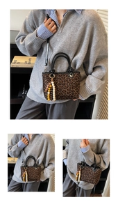 Détail du sac léopard avec poignées en cuir et breloque à pompon en perles colorées