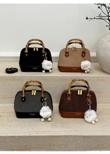Detail of four leopard print bags with bamboo handles and plush charm on stone steps