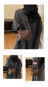 Détail du sac à main vintage à imprimé léopard avec pendentif en perles et bandoulière