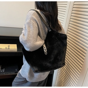 Detailed view of black plush tote bag with silver buckle closure and leather shoulder strap