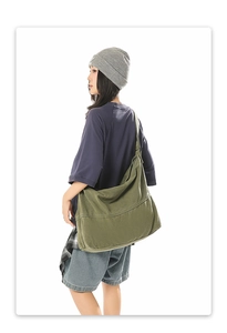 Vue latérale d'un grand sac hobo en toile vert olive montrant sa forme décontractée