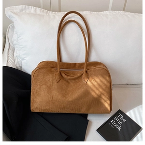 Brown suede tote bag on a white pillow with a black blazer for a premium aesthetic look