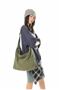 Détail du sac bandoulière en toile vert olive montrant le tissu épais et la sangle