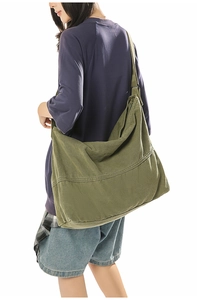 Vue latérale du grand sac bandoulière en toile vert armée montrant volume et tombé