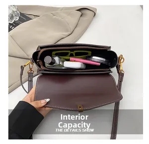 Vue intérieure du sac bandoulière marron foncé avec compartiment zippé et grande capacité