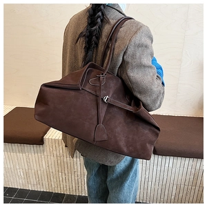 Close-up of a large brown suede tote bag featuring slim straps and minimalist tie details