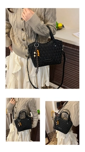 Detail of black quilted bucket bag featuring woven texture and unique beaded charm