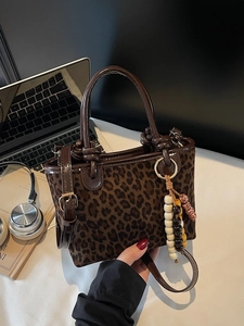 Sac à main rétro à motif léopard avec bandoulière et breloque en perles sur bureau