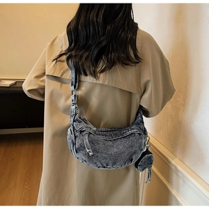 Detail der blauen Denim Hobo-Tasche mit verstellbarem Gurt und kleinem runden Münzbeutel