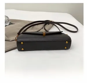 Vue détaillée du fond du sac en cuir grainé avec quatre pieds de protection dorés