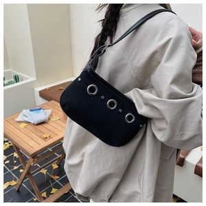 Détail du sac sous l'aisselle noir avec anneaux argentés et rivets sur matière suédée