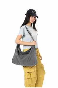 Détail de la large bandoulière réglable et des coutures sur le sac hobo en toile gris foncé