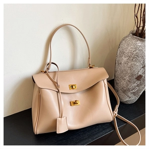 Detail of the minimalist cream tote bag with elegant golden double twist-lock closures