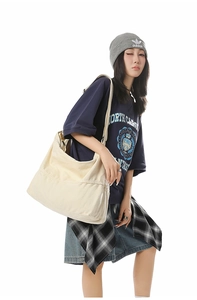 Détail d'un grand sac fourre-tout en toile blanc cassé avec texture souple et coutures