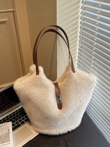 Large cream faux fur tote bag with brown leather handles and metal twist lock detail