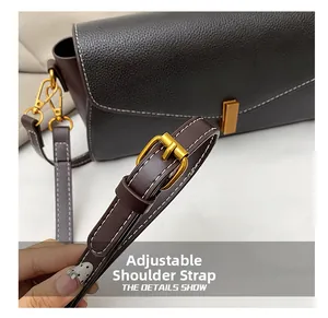 Détail de la bandoulière réglable avec boucle dorée sur un sac en cuir marron foncé