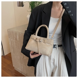 Detail der beige gefrosteten Wildleder Eimertasche mit Lederriemenschnalle und Metallschnalle
