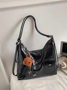 Large black glossy leather tote bag with stylish teddy bear charm and dual shoulder straps