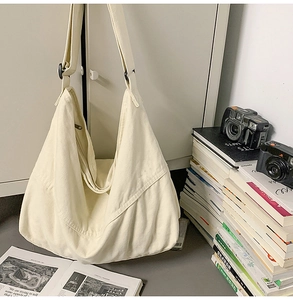 Détail du sac bandoulière en toile crème avec large sangle réglable et boucle noire